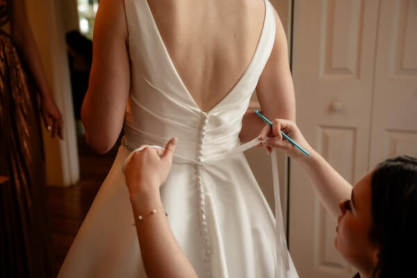 A wedding party helping a bride dress for her St. Pete wedding.