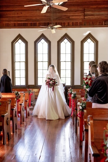 The bride is walking down the aisle at her Tampa Bay wedding.