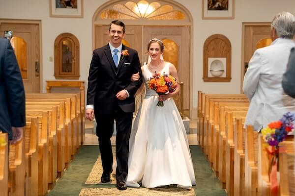 A birde and groom walking down the aisle together at their St Pete wedding.