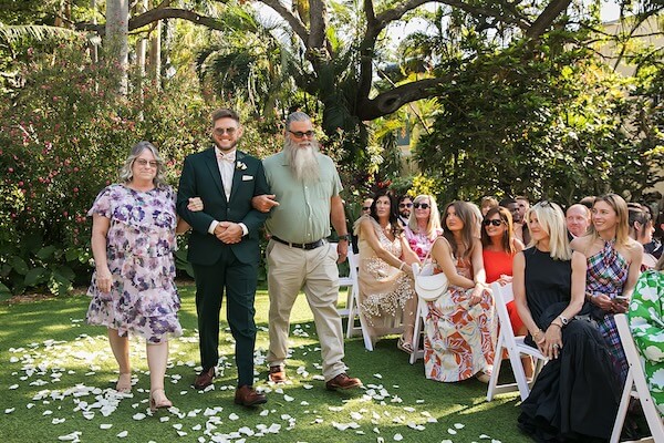 A groom and his parents walk down the aisle at his St. Petersburg, Florida, wedding.