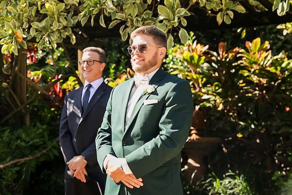 Groom watching his bride walk down the aisle.