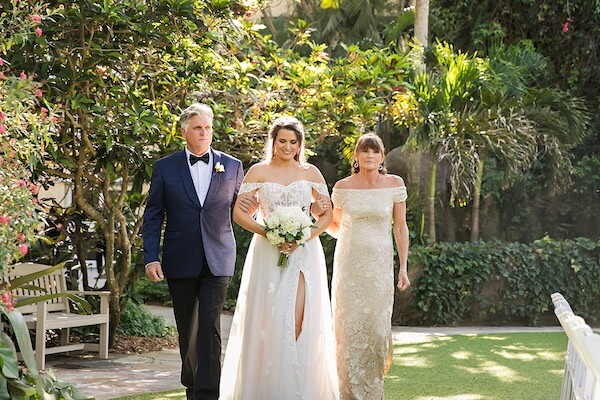 The bride and her parents are walking down the aisle to Canon in D.