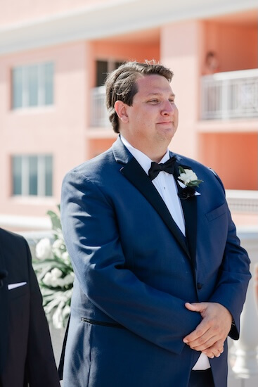 An emotional groom watching his bride walk down the aisle.