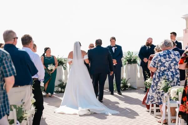 A bride and her father walking down the aisle.