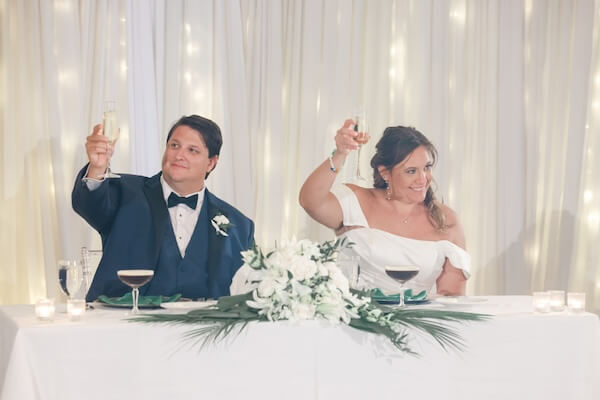 A bride and groom toasting during her father's wedding toast.