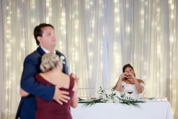 A Clearwater Beach bride is watching her groom dance with his mother.