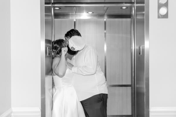 The bride and groom are in the elevator of the Hyatt Regency Clearwater Beach at the end of their wedding reception.