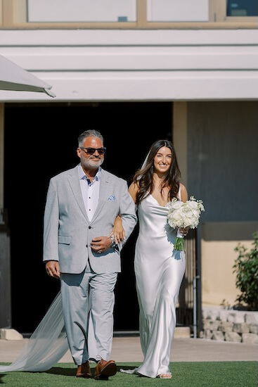 A bride and her father walking down the aisle at the Sandpearl Resort.