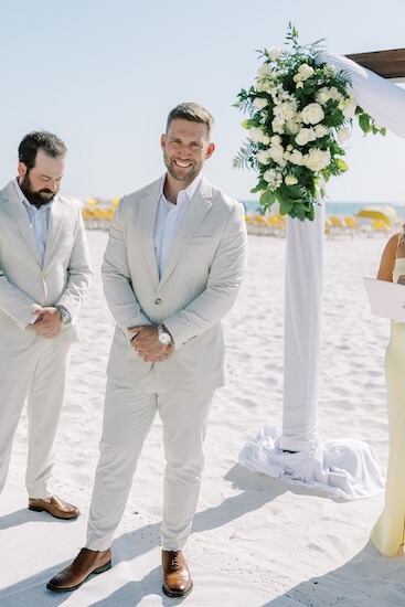 A groom looking on as his bride-to-be walks down the aisle.
