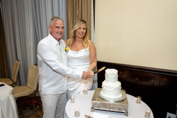 The bride and groom are cutting their wedding cake.