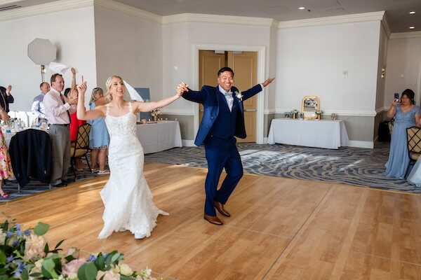 A newlywed couple makes a grand entrance at their wedding reception.