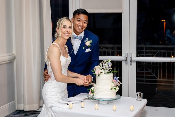 A bride and groom cutting their wedding cake.