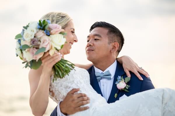 Groom carrying his bride across Clearwater Beach.
