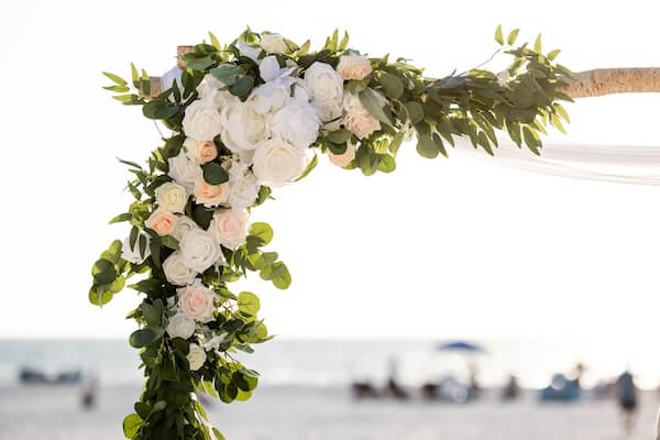 Greenery and silk flowers on a wedding arch.