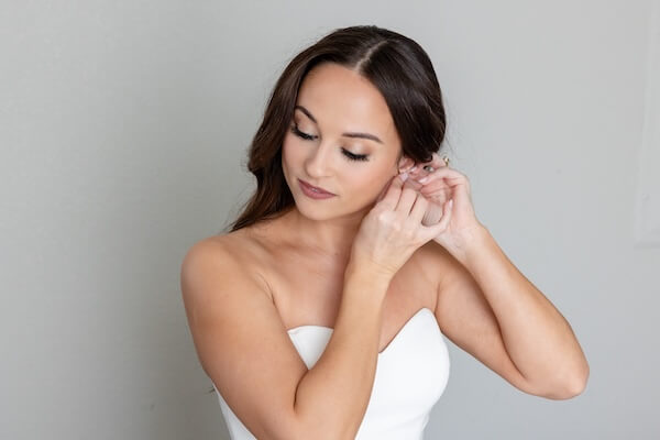 A bride putting on her earrings.