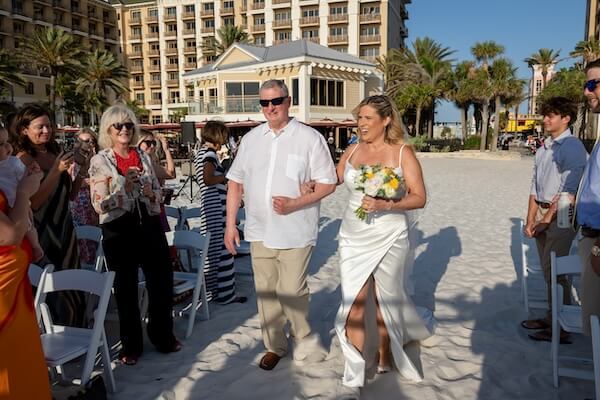 A bride walking down the aisle at her wedding ceremony on Clearwater Beach.