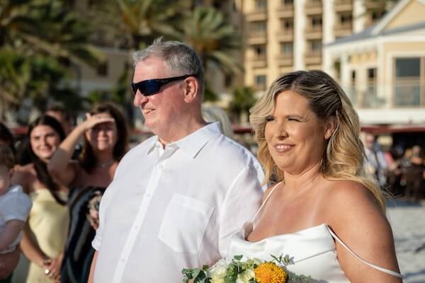 A bride walking down the aisle with her father at her wedding ceremony on Clearwater Beach.