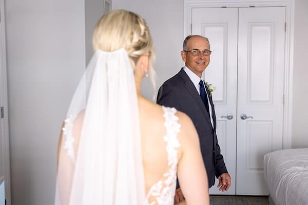 A dad has his first look and private moment with his daughter before her Hyatt Clearwater wedding.