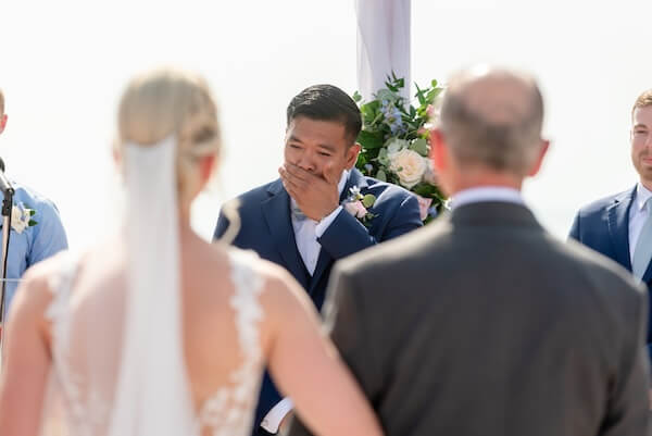 A groom breaking down with emotion as he bride approaches.