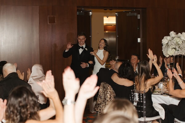A bride and groom making their grand entrance at their Opal Sands wedding reception.