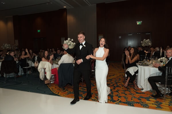A bride and groom making their grand entrance at their Opal Sands wedding reception.