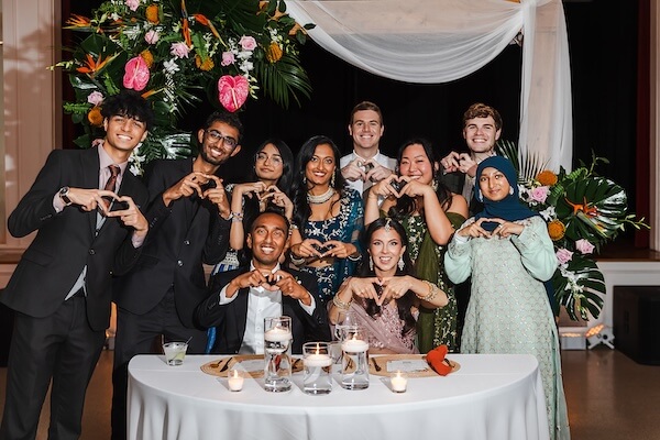 Wedding guests stopping at the couple's sweetheart table for some fun photos.