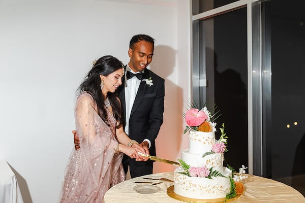 A bride and groom cutting their wedding cake.