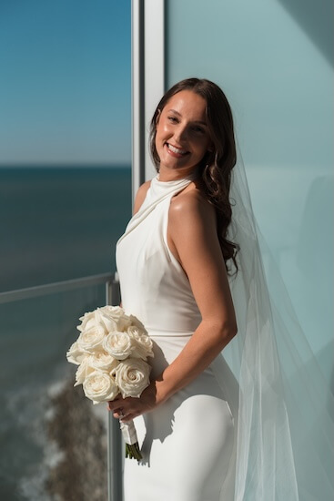 A bride on the balcony of her suite beofre her Opal Sands wedding.