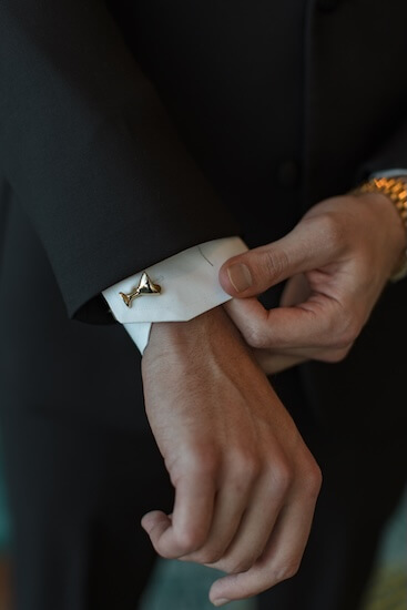 A groom wearing martini glass cufflinks.