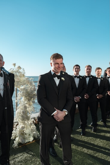 A groom watching his bride walk down the aisle.