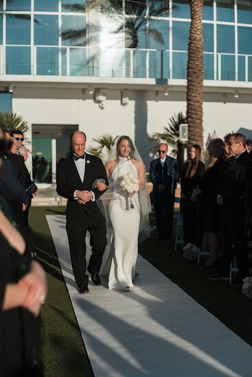A bride and her father walking down the aisle.