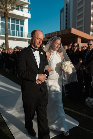 A bride and her father walking down the aisle.