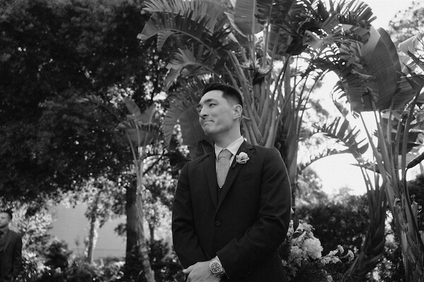 A groom looking non as his birde walks down the aisle at thier Tampa Garden Cliub wedding.