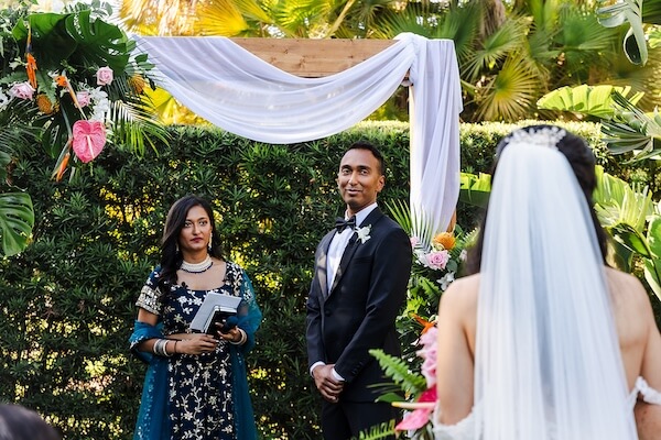 A groom looking on as his bride walks down the aisle.