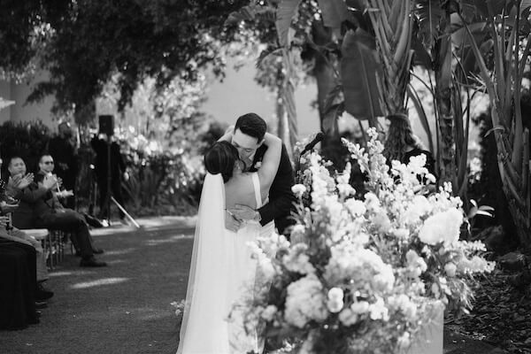 A bride and groom bealing thier bond with a kiss.