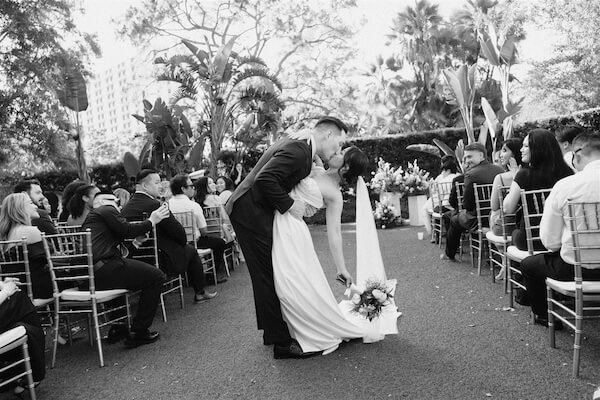 A birde and groom kissing after thier outdoor Tampa wedding.