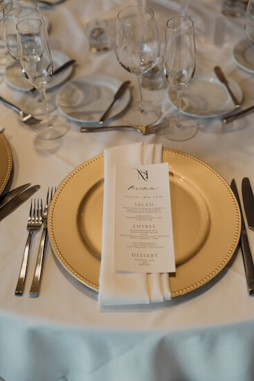 Gold charger plates and custom menu cards for an Opal Sands wedding reception.