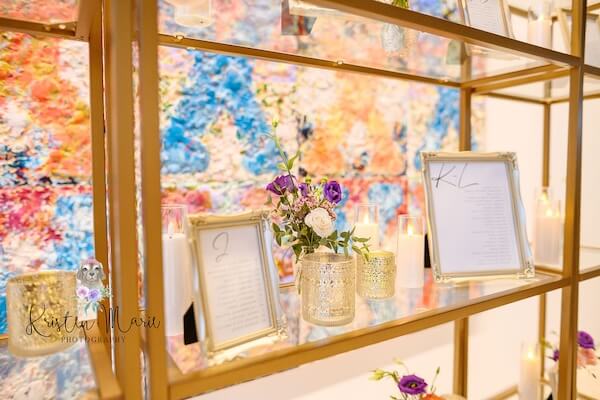 Gold shelving used as an elegant seating chart for a Tampa Museum of Art wedding.