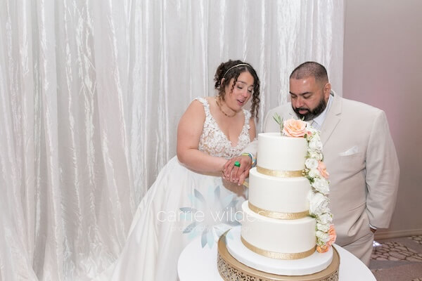 A newlywed couple cutting thier wedding cake during their Wyndham Grand Clearwater Beach wedding reception.