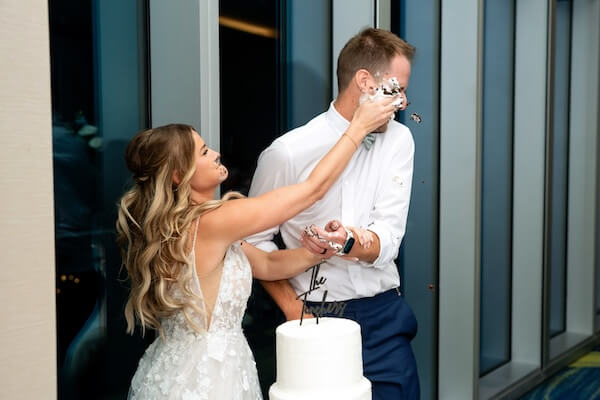 Bride smashing wedding cake in her new hisband's face.