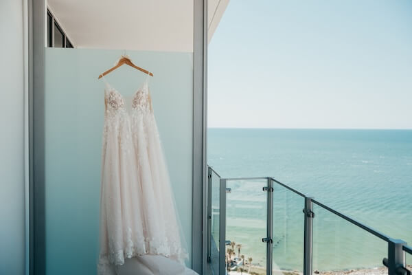 Wedding gown hanging on the balcony of an Opal Sands bridal suite.
