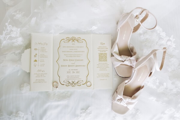 Wedding invitation and brides shoes.
