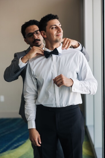 Best man helping the groom fix his tie.
