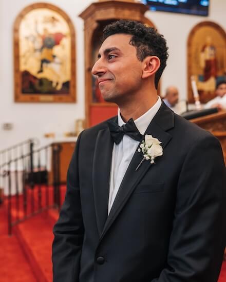 Groom looks on as a bbirde makes her way down the aisle.