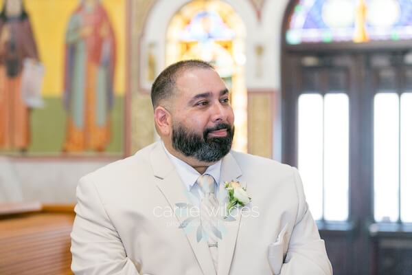 A groom waiting for his bride to walk down the aisle at St. Nicholas Greek Orthodox Church in Tarpon Springs, Florida.