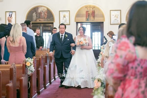A bride walking down the aisle during her Tarpon Springs wedding ceremony.