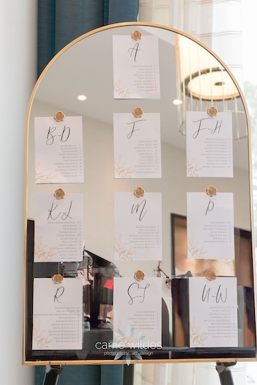 A gold mirrored seating chart by Special Moments Event Planning.