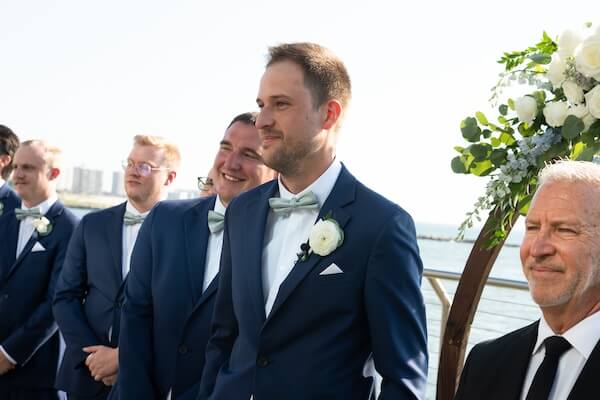 A groom watching as his bride to be walks down the aisle.