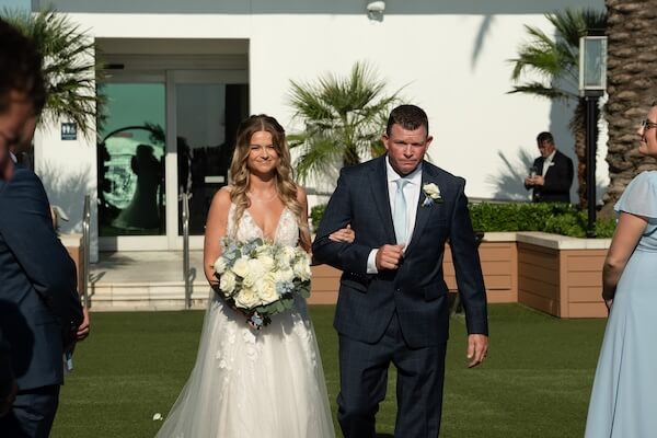 A bride walking down the aisle at her Opal Sands wedding.