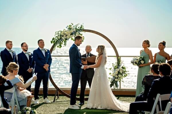 A bride and groom exchanging rings at their Opal Sands wedding.